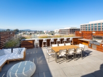 Roof top with bbq, white couches, chairs and table